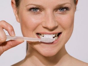 mujer cepoillandose los dientes para prevenir la placa dental y la gingivitis